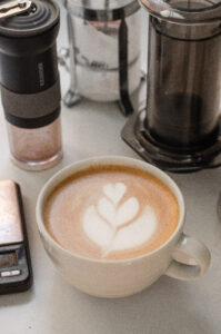 A white mug with a homemade latte and tulip latte art.