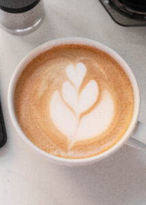 A white mug with a homemade latte and tulip latte art.