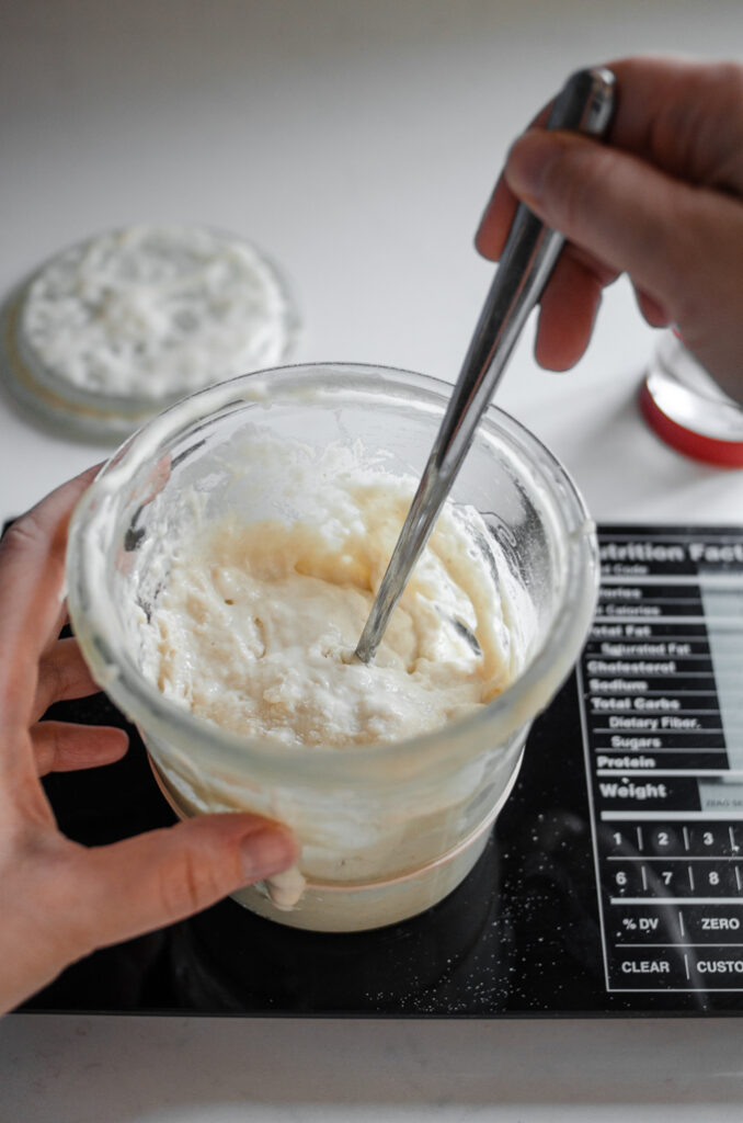 Stirring a sourdough starter in a Weck jar.