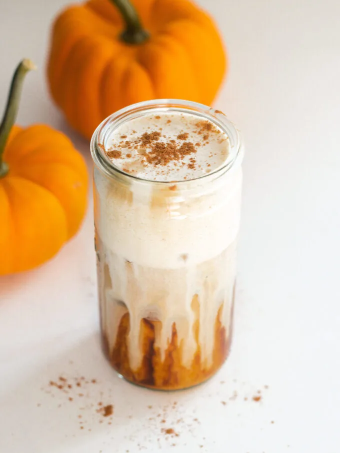 A glass of pumpkin cold foam with pumpkin pie seasoning sprinkled on top.