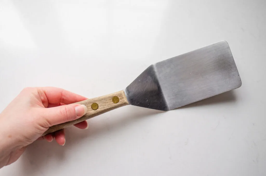 A stainless steel spatula on a white countertop.