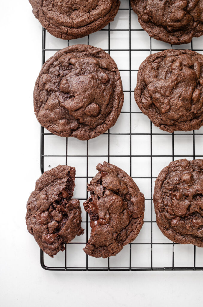 Chocolate espresso cookies on a wire cooling rack on a white countertop.