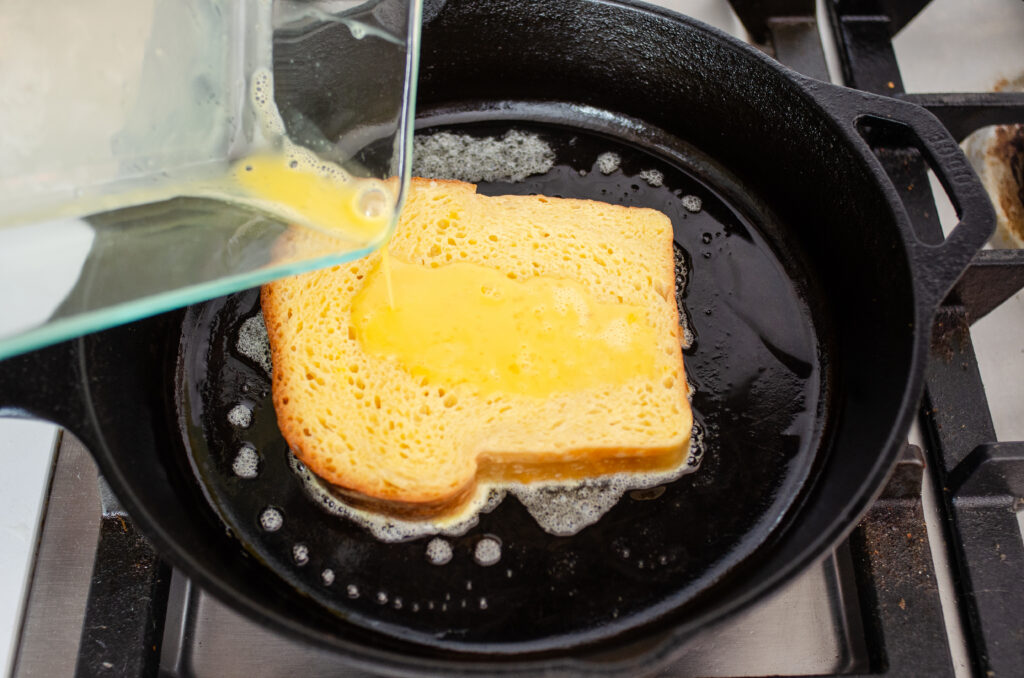 Adding the soaked bread to the hot buttered cast iron skillet.