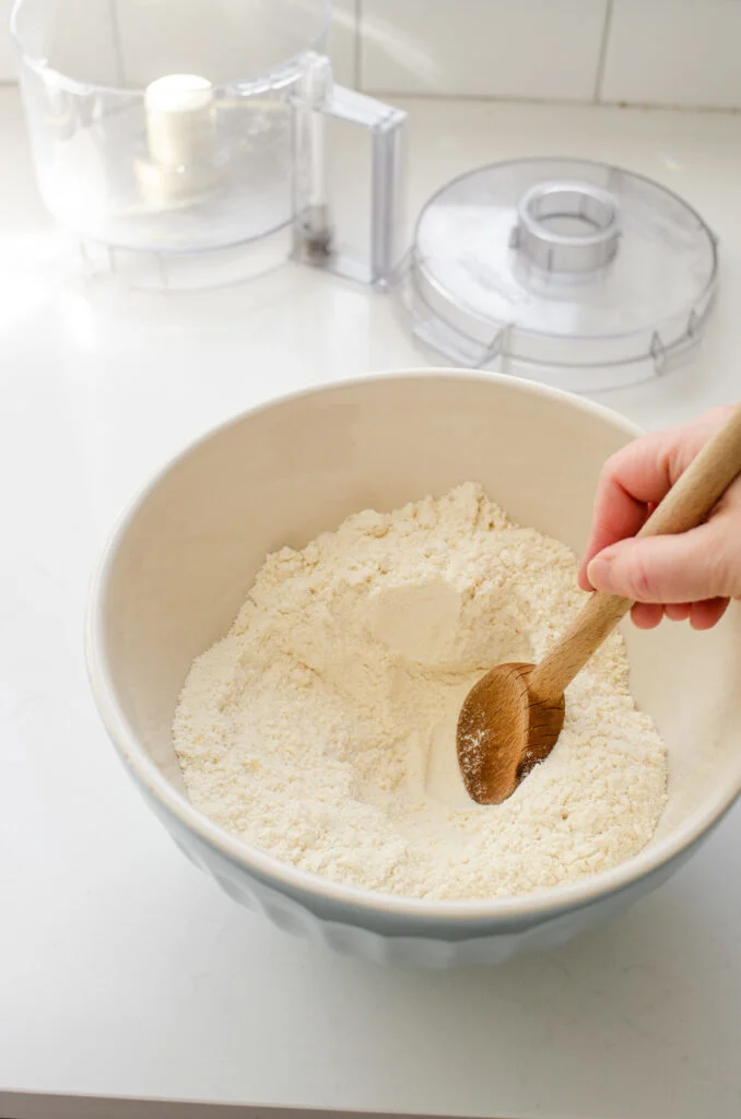 Making a well in the dry ingredients with a wooden spoon.