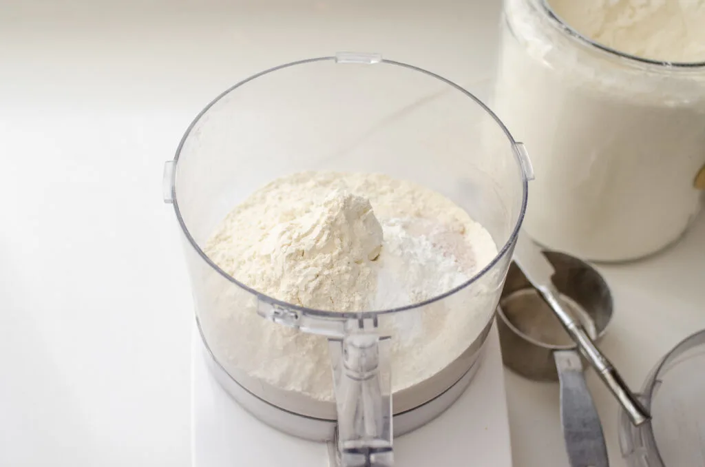 All of the dry ingredients in a food processor bowl.