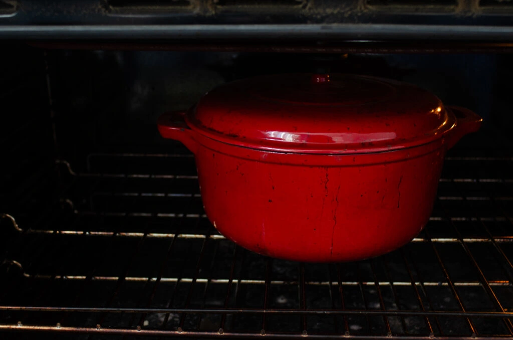 An enameled Dutch oven in an oven to preheat.
