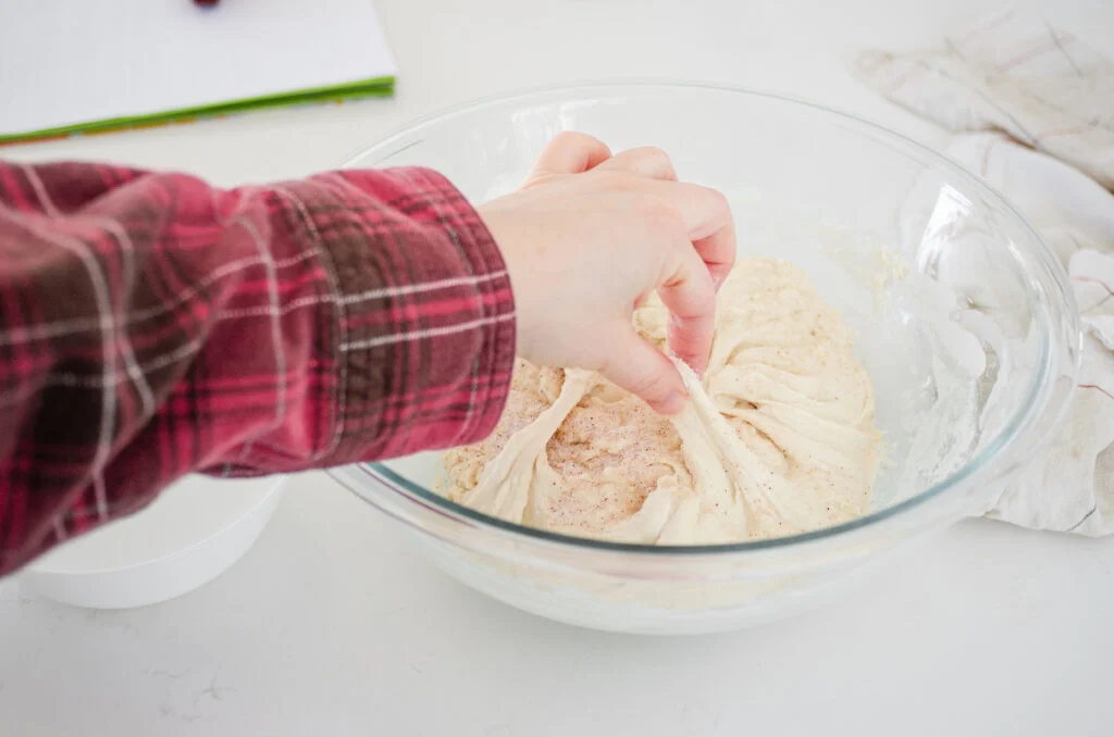 Mixing the salt into the dough by pinching it.