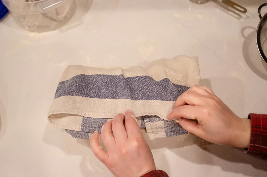 Folding the tea towel over the loaf before placing it in the fridge for the cold ferment.
