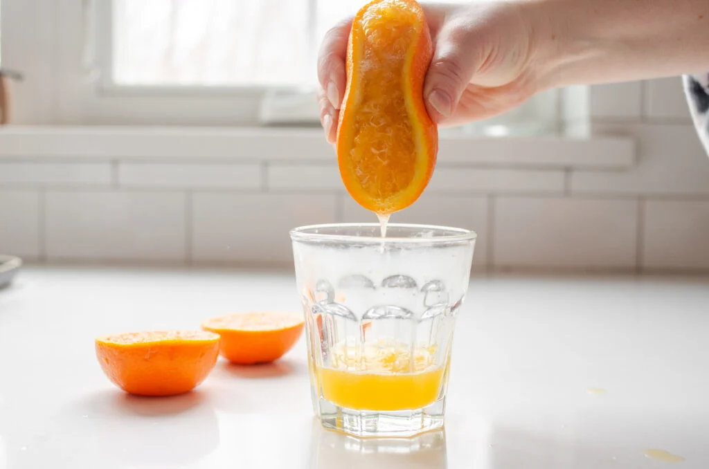 Using your hands to squeeze the juice out of an orange.