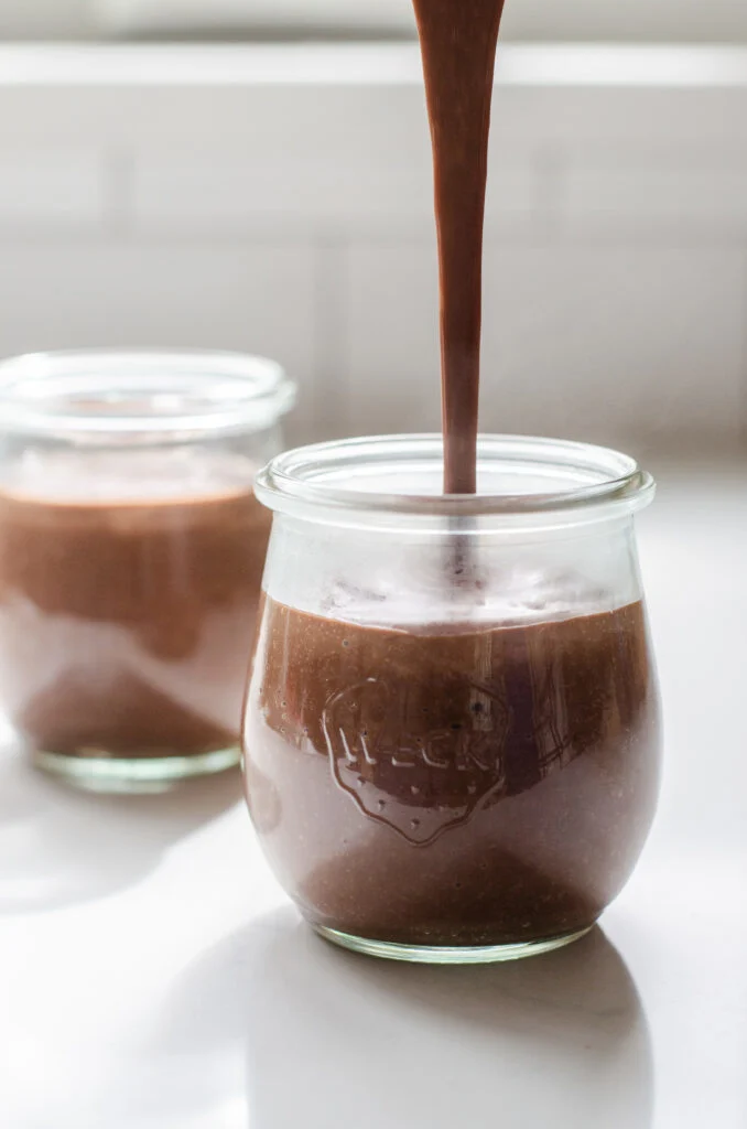 Pouring the hot chocolate pudding into serving jars.