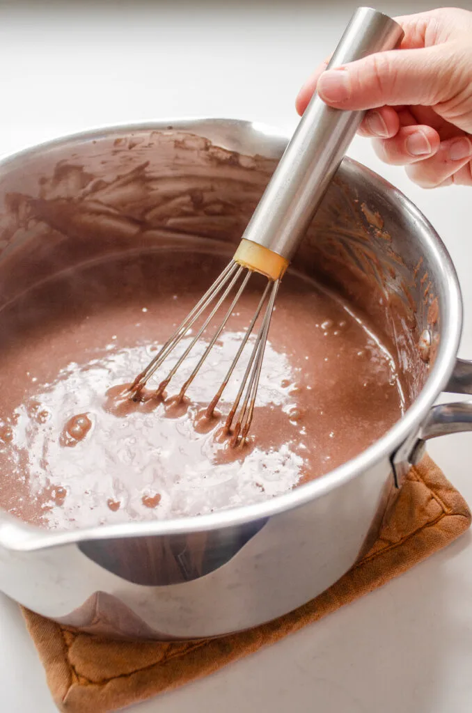 Whisking the butter and vanilla extract into the pudding until well combined.