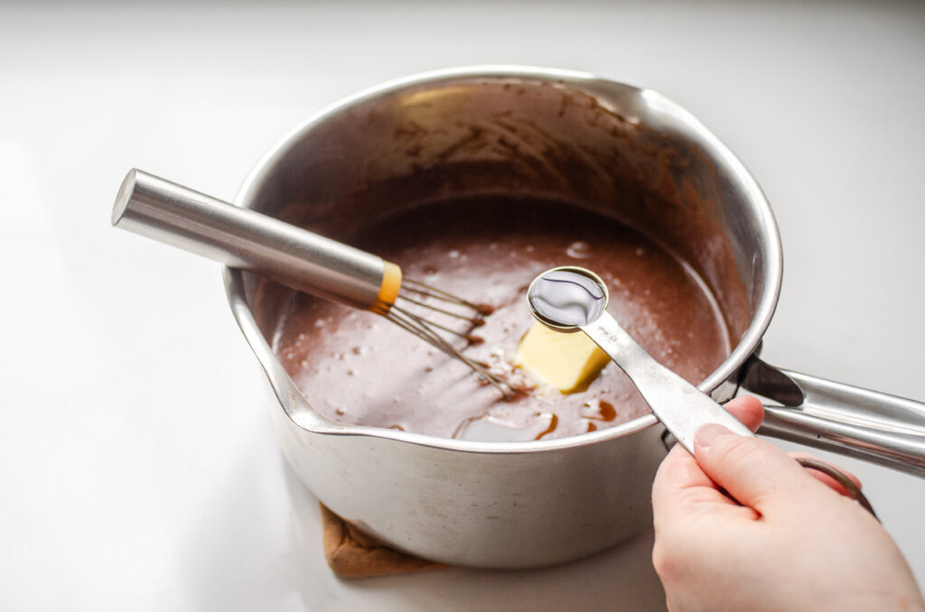Adding the vanilla extract to the pot.