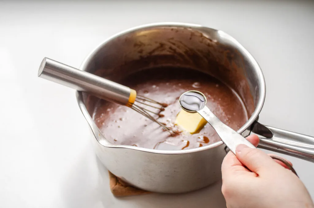 Adding the vanilla extract to the pot.