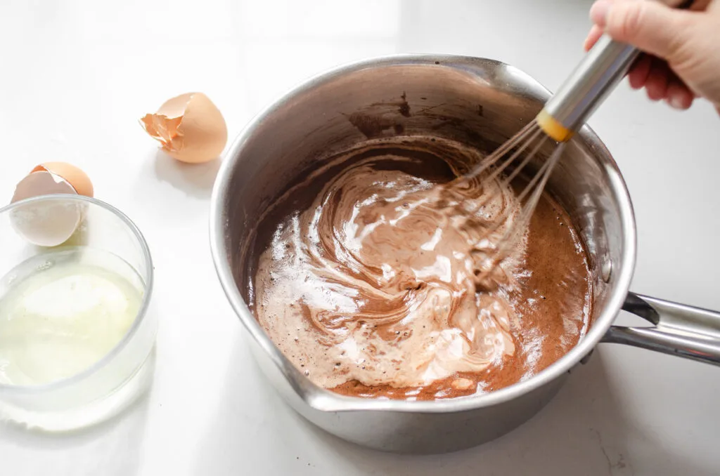 Whisking in the remaining milk.