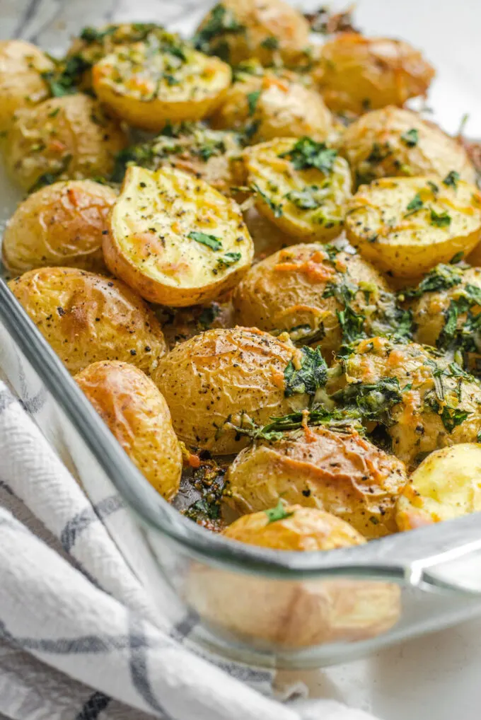 A pan of roasted little potatoes with garlic, lemon, rosemary, parsley, and parmesan cheese.
