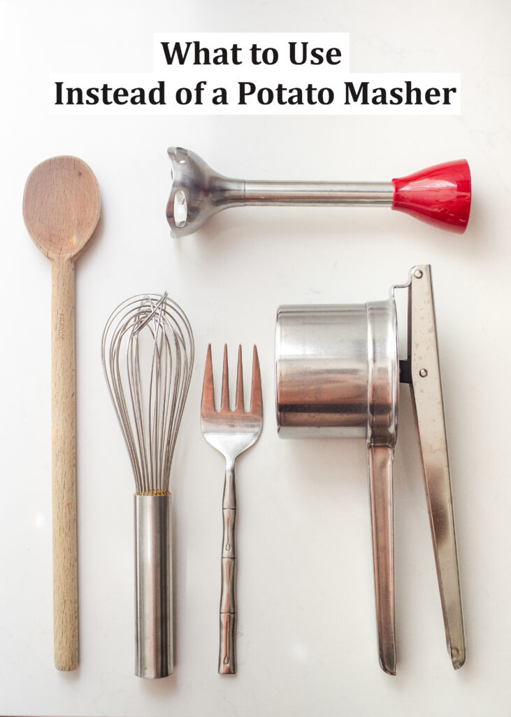 Different kitchen tools that you can use to mash potatoes laid out on a white countertop.