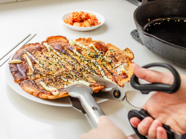 Cutting the sourdough discard kimchi pancake with scissors.