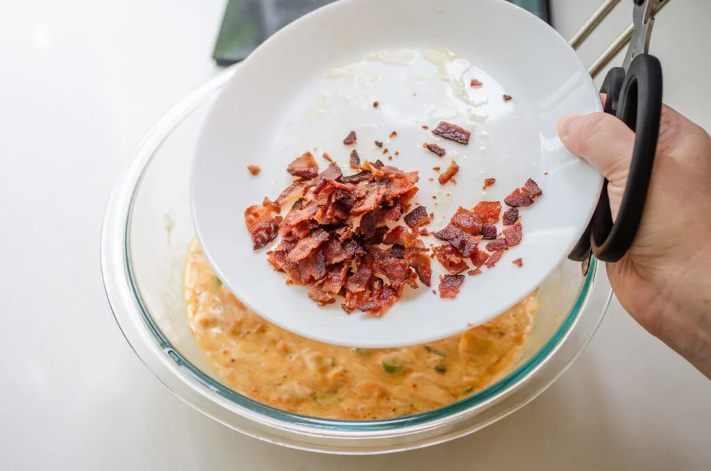 Adding the bacon to the bowl.