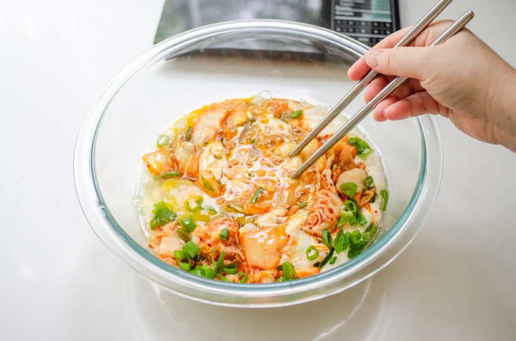 Mixing the ingredients for the kimchi pancake together with chopsticks. 