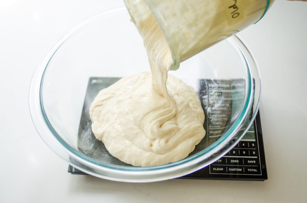 Pouring sourdough discard into a bowl.