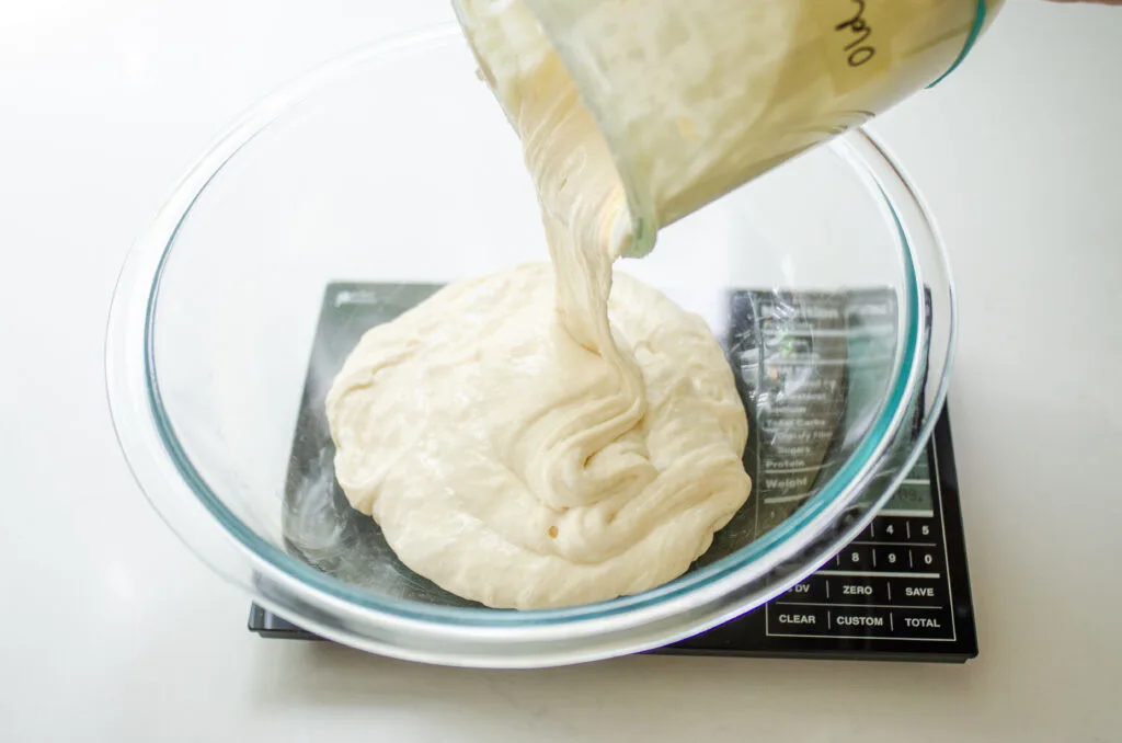 Pouring sourdough discard into a bowl.