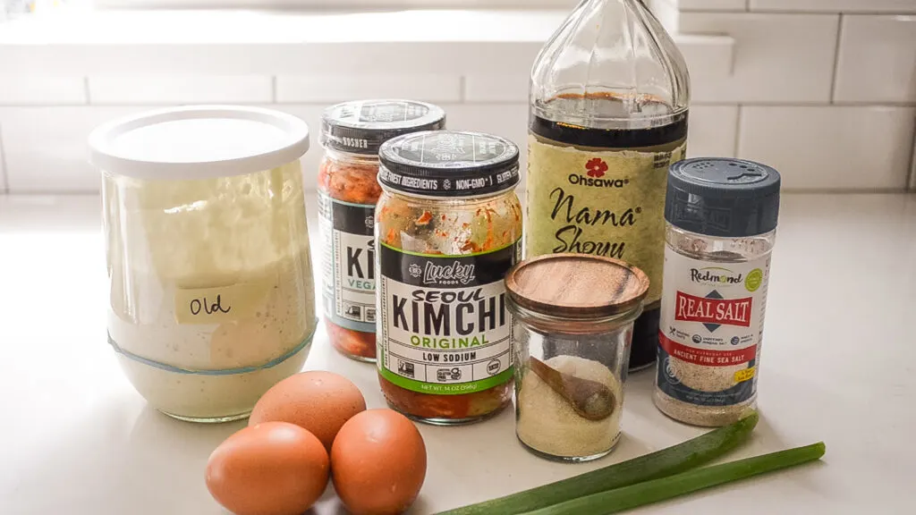 All of the ingredients needed to make a sourdough discard kimchi pancake laid out on a white countertop.