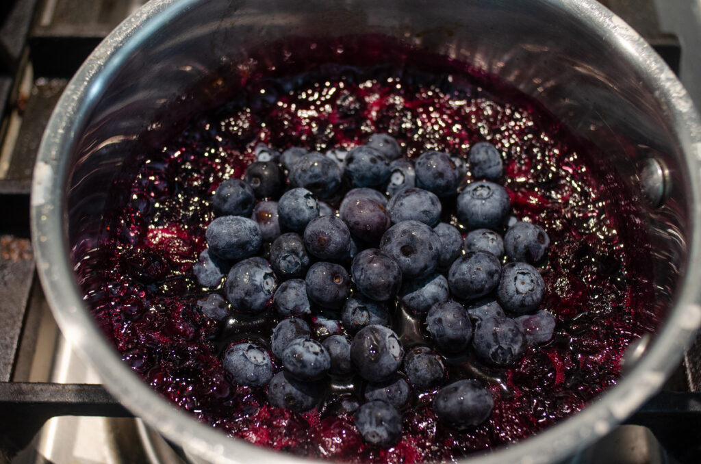 Adding the remaining cup of fresh blueberries to the pan.