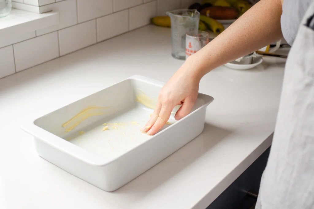 Buttering a baking dish.