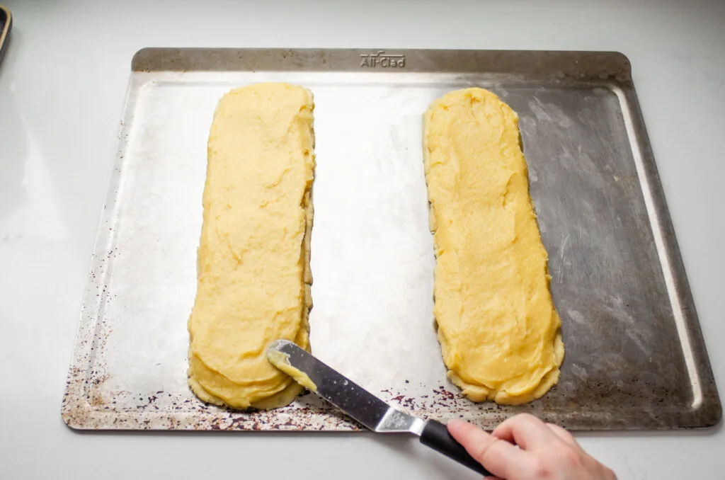 Spreading the choux pastry on top of the short crust pastry.