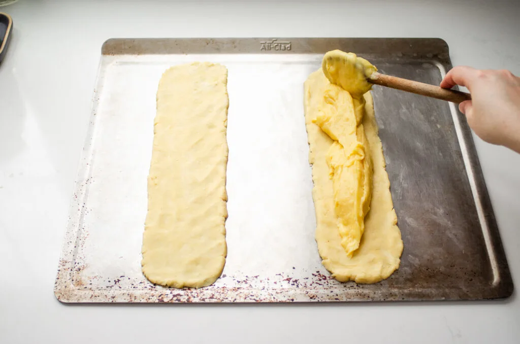 Spreading the choux pastry on top of the short crust pastry.