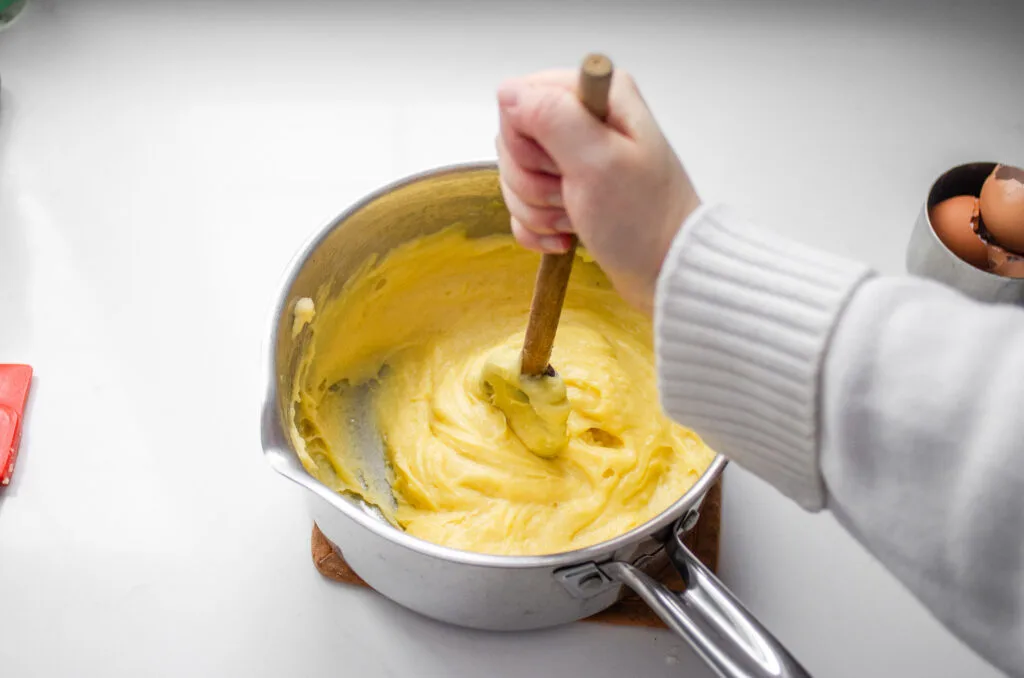 Beating the eggs into the choux pastry.