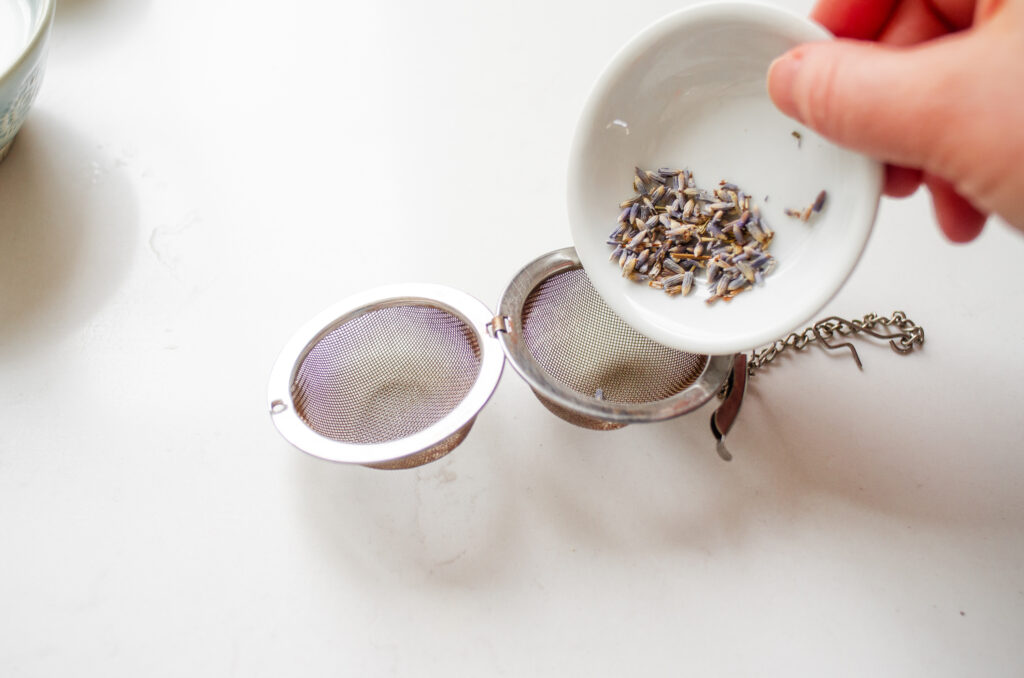 Placing lavender buds in a mesh tea steeper. 