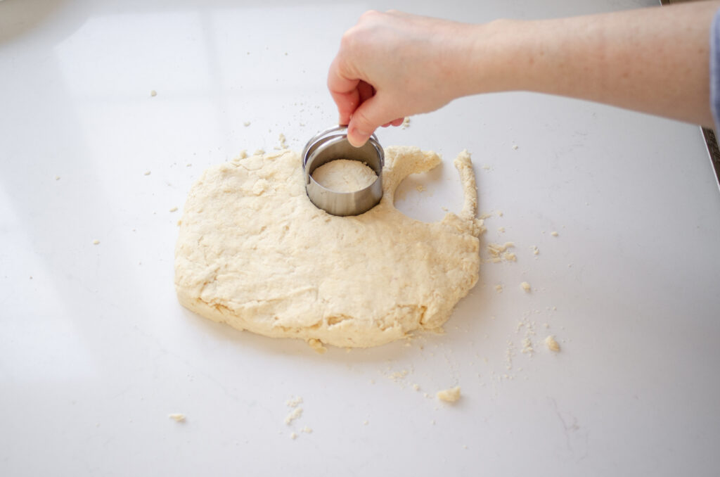 Cutting out the scones with a 2-inch biscuit cutter.
