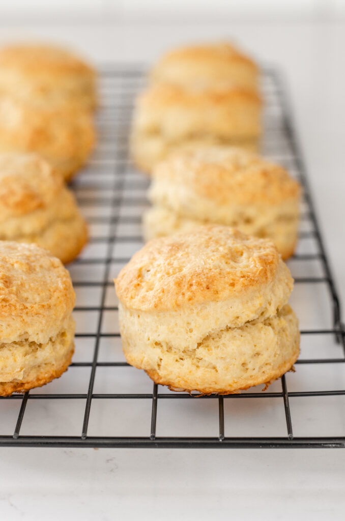 Sourdough scones on a wire cooling rack on a white countertop.