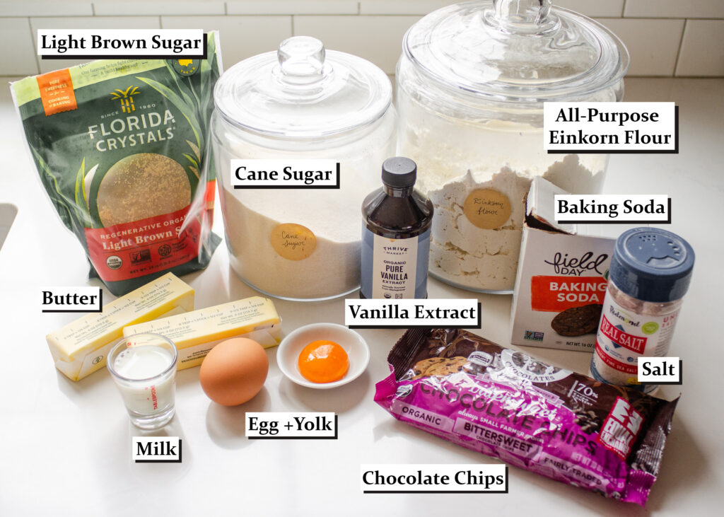 All of the ingredients needed to make einkorn flour chocolate chip cookies laid out on a white countertop.