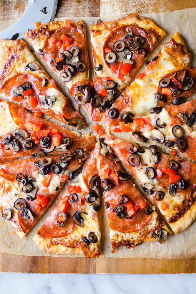 An einkorn flour pizza on a cutting board sliced into triangular pieces.