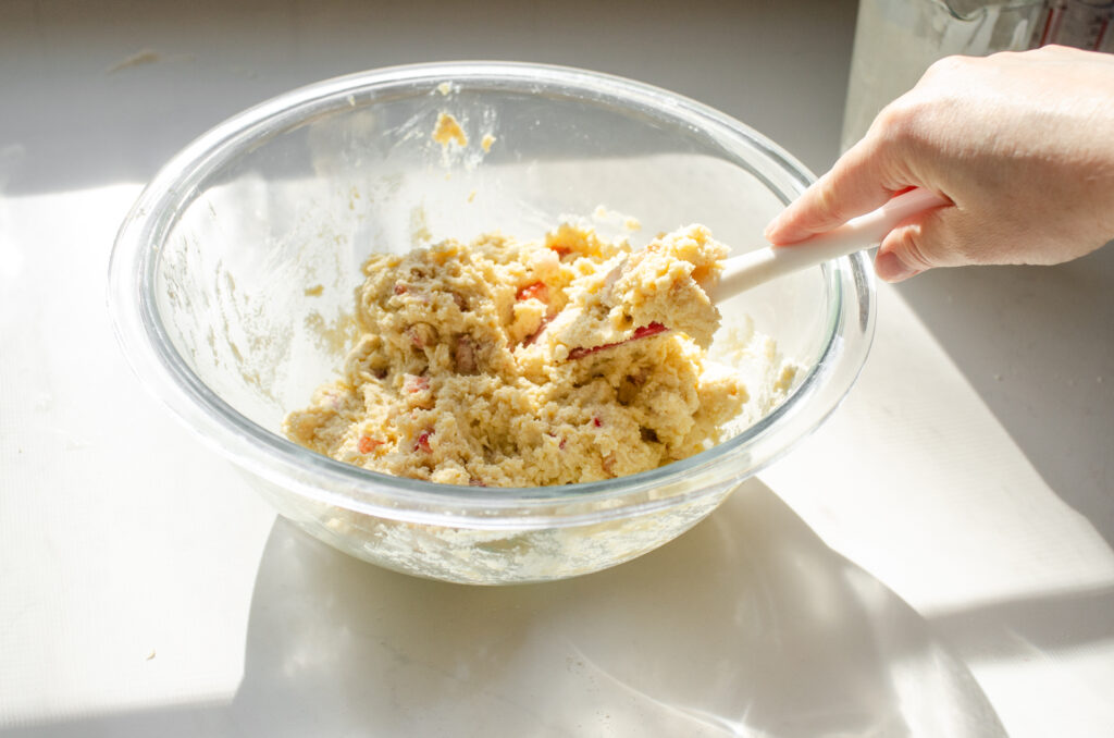Mixing together the wet and dry ingredients in a large bowl to make a sticky dough.