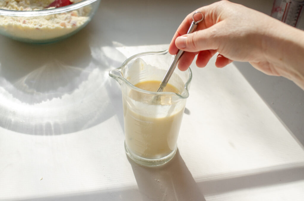 Whisking together the wet ingredients in a small measuring cup.