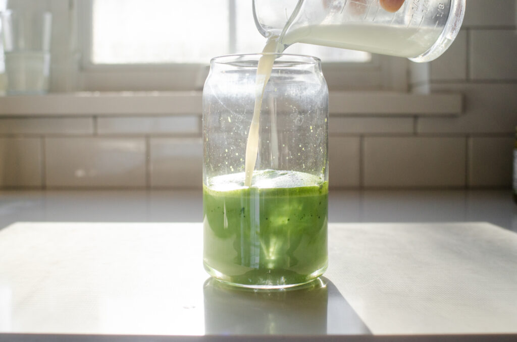Pouring the milk over the simple matcha mixture.