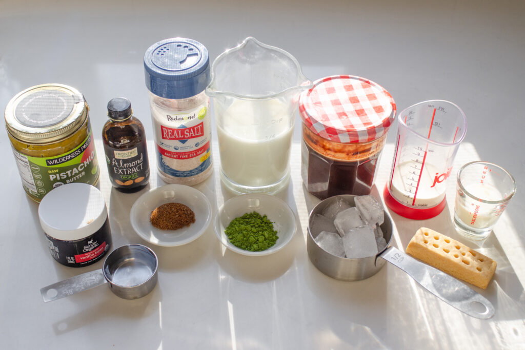 All of the ingredients needed to make the more natural version of the Starbucks iced Dubai chocolate matcha latte.