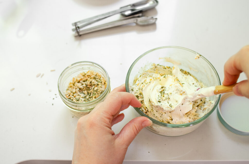 Folding the onion dip mix into the sour cream with a spatula.
