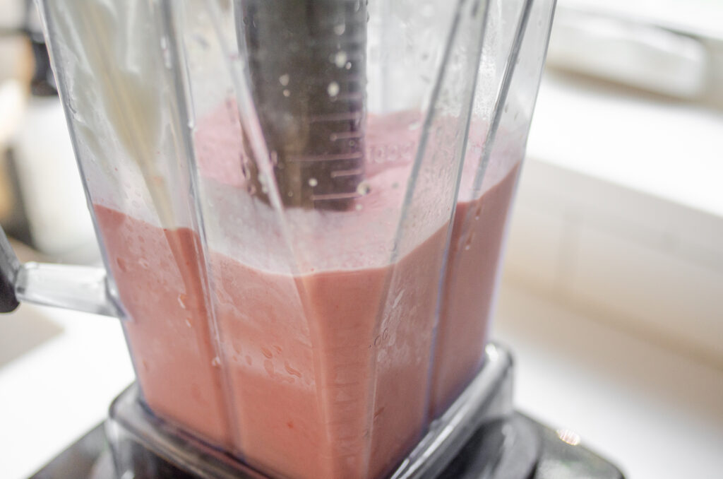 A close up shot of the blender pitcher showing the nicely blended smoothie. 