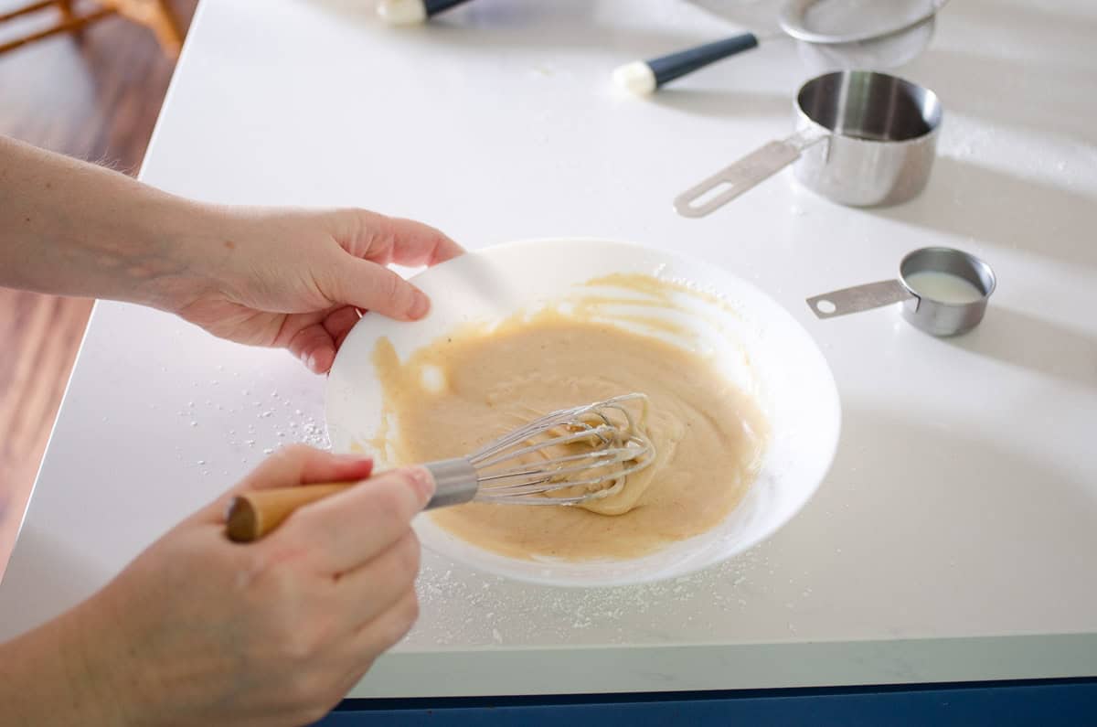 Whisking together all of the frosting ingredients until completely smooth.