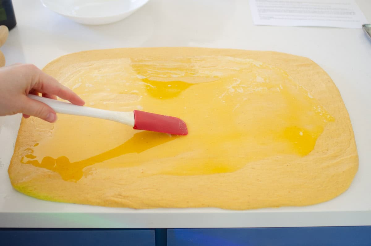 Spreading the melted butter over the dough.