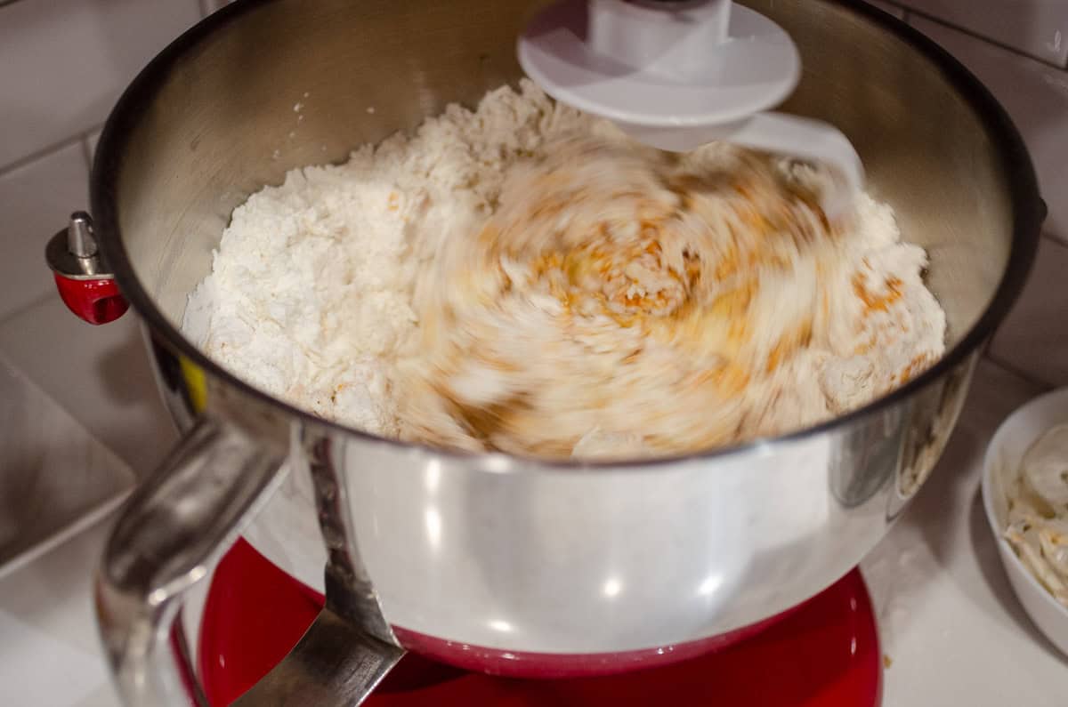 The dough being mixed in the stand mixer with the hook attachment.